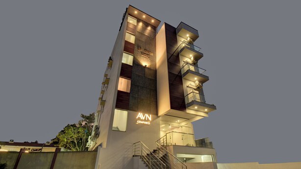 A modern building with a prominent 'AVN COMFORTS' sign, multiple balconies, and a staircase leading to the entrance. - AVN Comforts Mysore (Mysore)