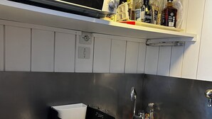 A kitchen with a microwave, sink, and countertop storage. - Studio les arcs ski pied immeuble (Bourg-Saint-Maurice)
