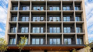 A multi-story hotel with a modern architectural design, featuring balconies, a covered entrance, and a landscaped entrance area. - Stay Americana district in Guadalajara near La Minerva & Chapultepec (Guadalajara)