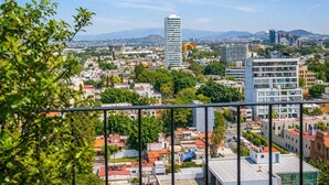 A cityscape with modern buildings, a prominent skyscraper, and a view of the surrounding urban area. - Stay Americana district in Guadalajara near La Minerva & Chapultepec (Guadalajara)