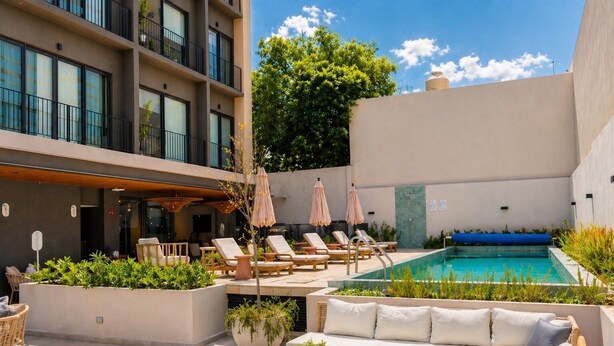 A rooftop pool area with lounge chairs, a sofa, and umbrellas. - Stay Americana district in Guadalajara near La Minerva & Chapultepec (Guadalajara)