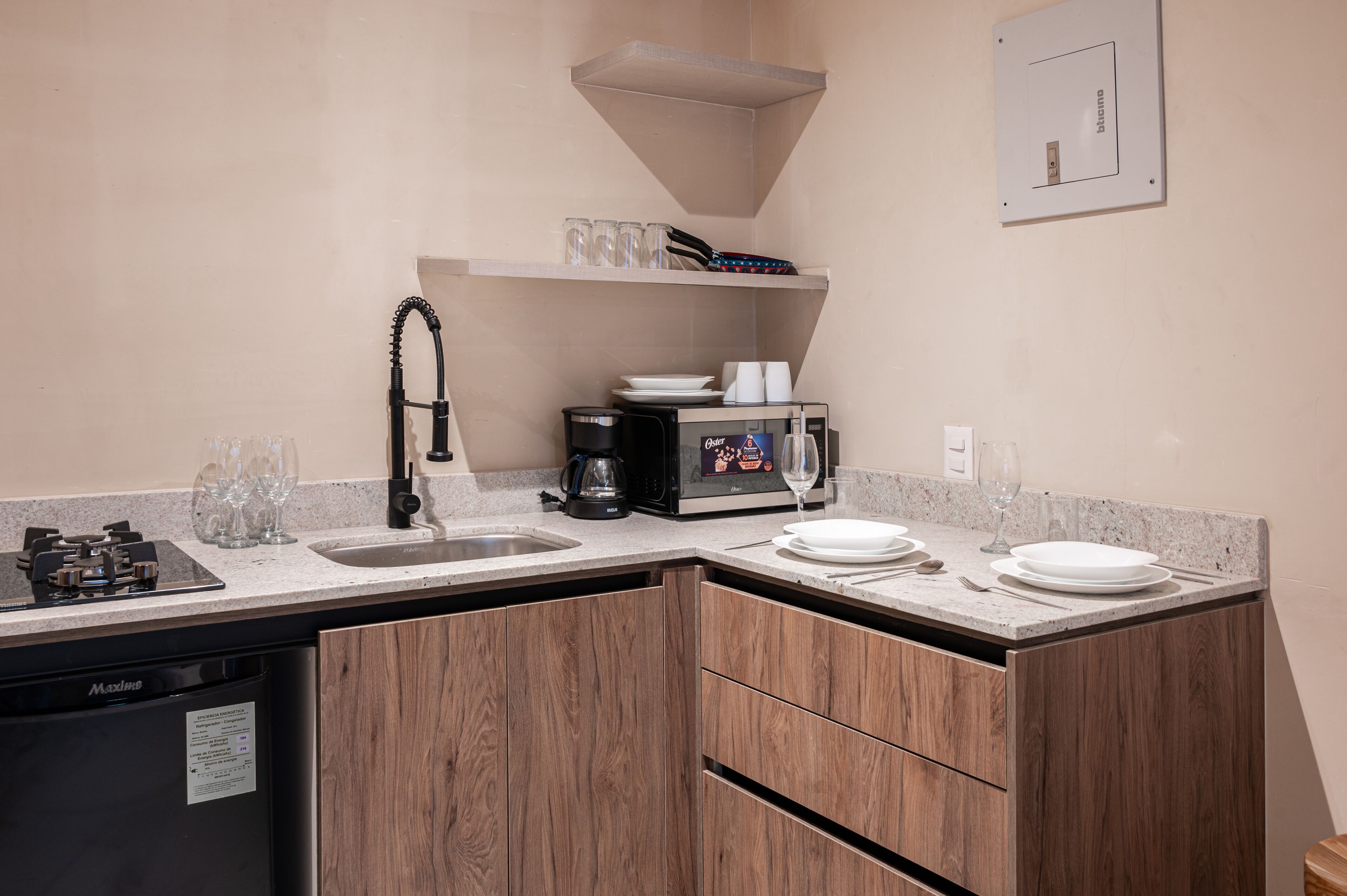 Een kleine keuken met een vaatwasser, koffiezetapparaat en een magnetron.