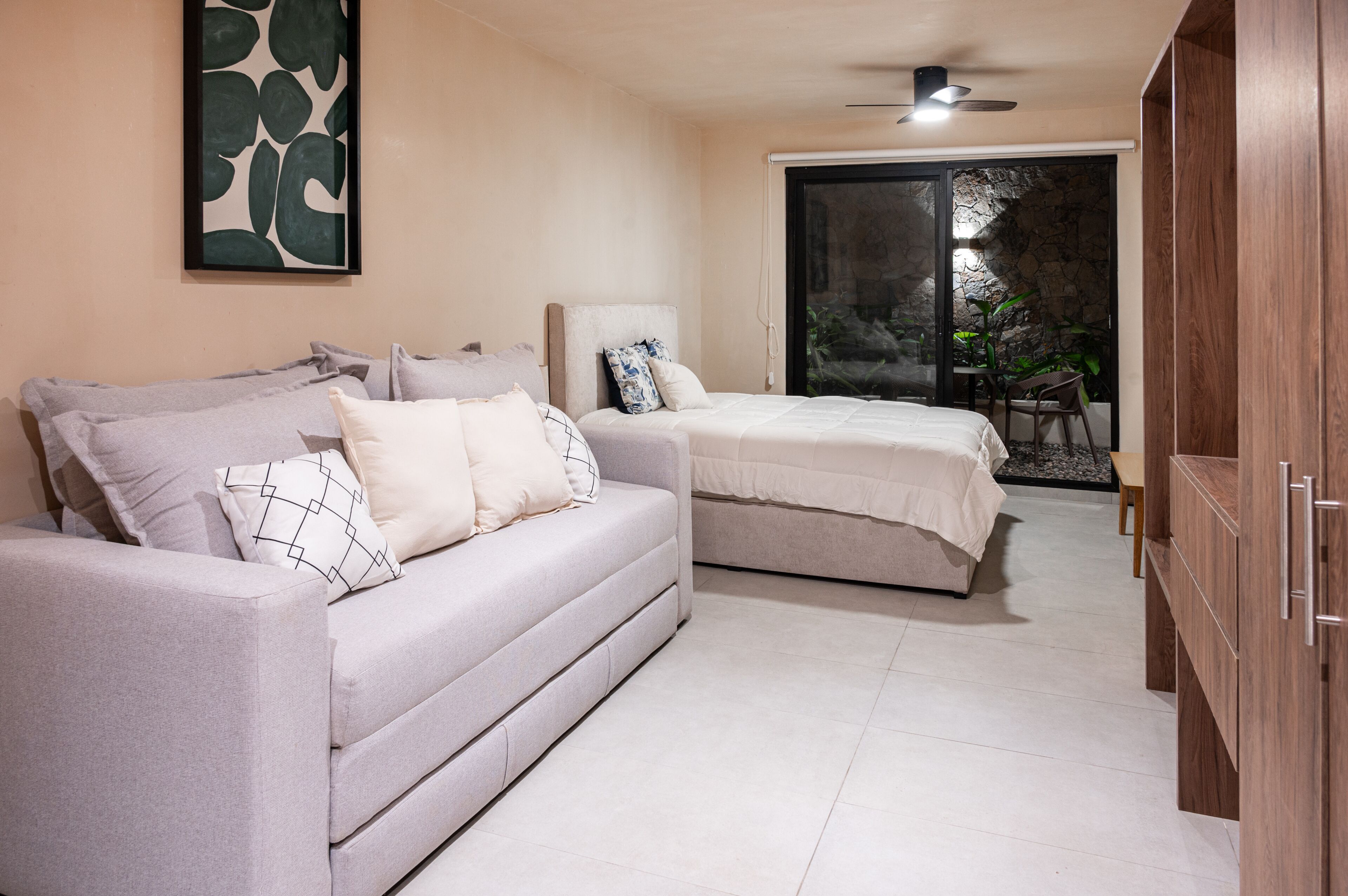 Un dormitorio con sofá, cama, silla y armario.