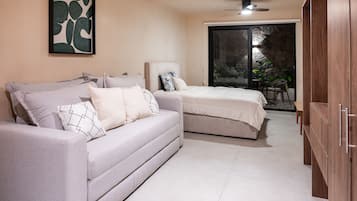 Un dormitorio con sofá, cama, silla y armario.