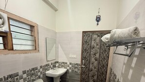 A bathroom with a toilet, sink, and shower. - Vanah Stays (Heggadadevankote)