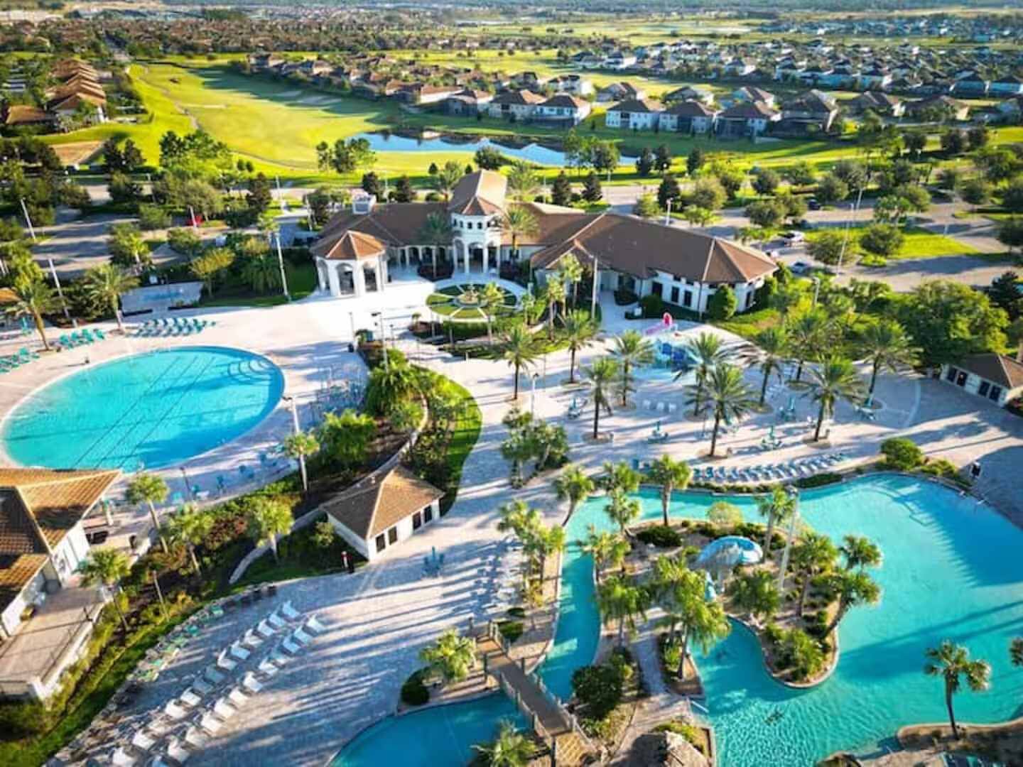 A resort with multiple swimming pools, a golf course, and residential buildings.