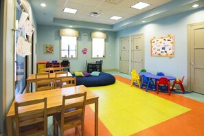 A children's playroom with tables, chairs, and colorful play mats. - 9BR Fairytale Kingdom Sleeps 24 Pool Near Disney (Kissimmee)