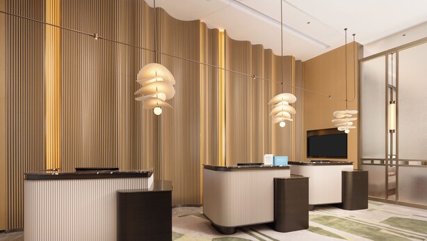 Uma área de recepção de hotel com design moderno, apresentando um balcão de recepção, uma televisão de tela plana e luminárias contemporâneas.