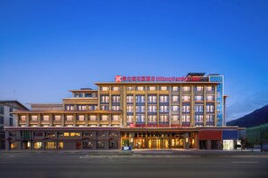Un hôtel à plusieurs étages, reconnaissable à son enseigne bien visible indiquant « Hilton Garden Inn ».