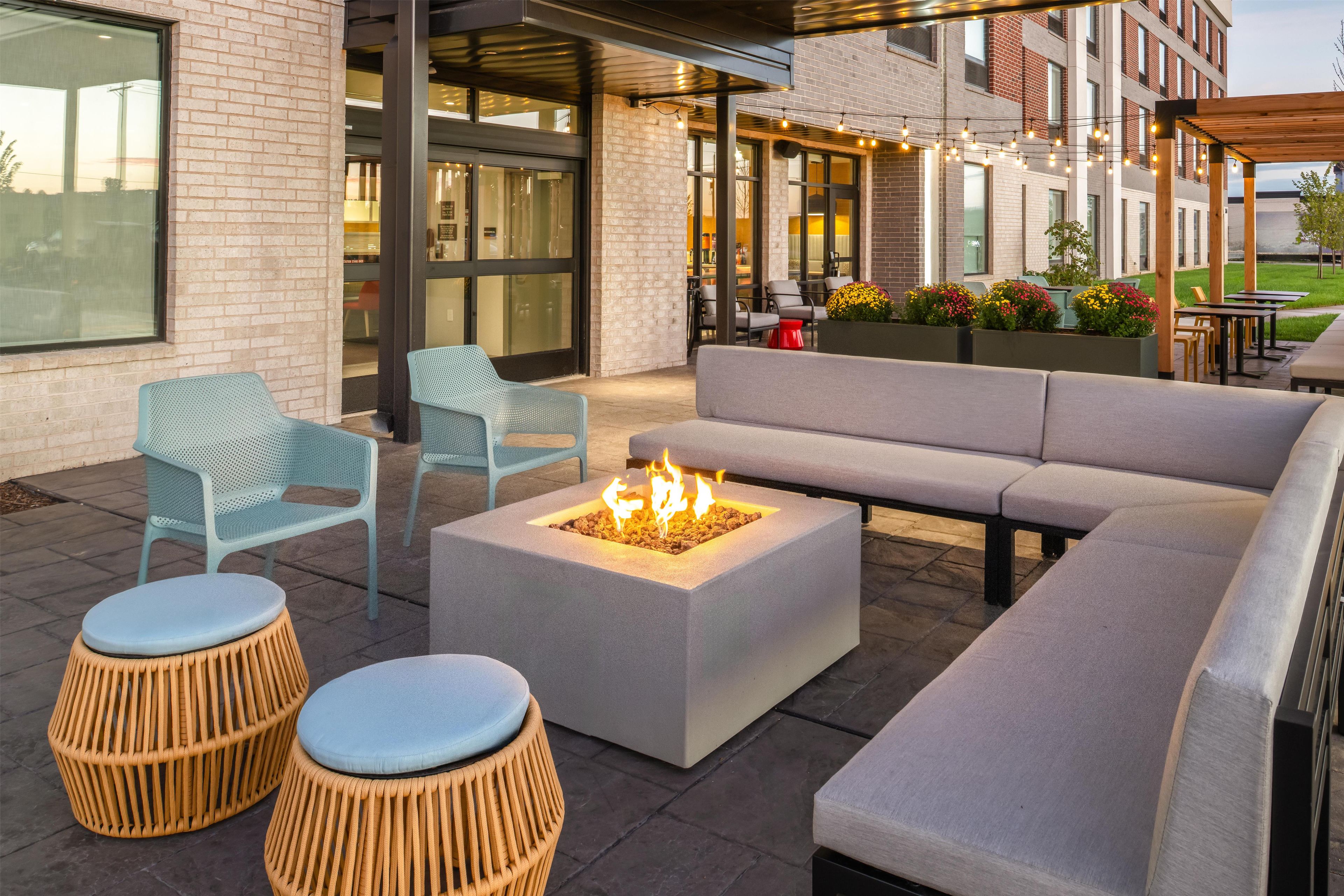 An outdoor seating area with a fire pit, sofas, and chairs.