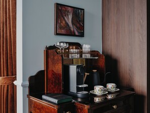 A coffee station with a coffee machine, cups, and a book on a wooden table. - NoMad Hilton Singapore (Singapore)