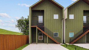 A building with two identical units, each with a balcony and a staircase. - 3BR Modern Home 15 Min to NRG, Downtown & Hobby (Houston)