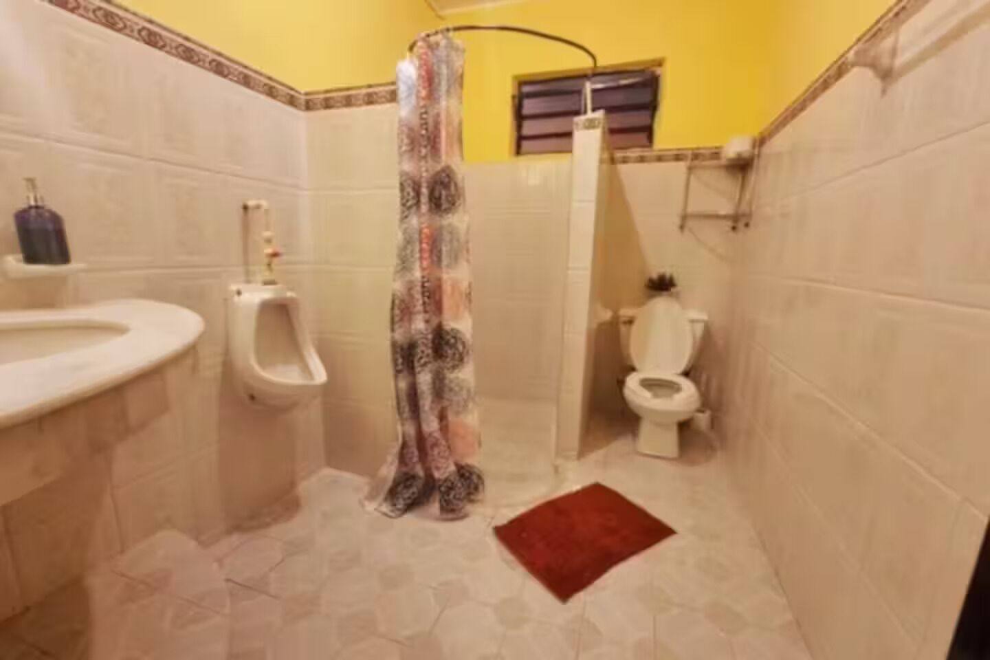 A bathroom with a toilet, urinal, and sink.