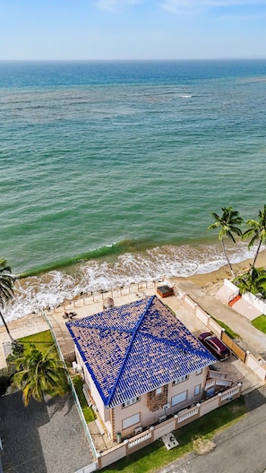 A beachfront property with a tiled roof, a pool, and a view of the ocean. - 2-story villa with ocean views, hot tub, 180° ocean views, and sunsets – sleeps 8   (Aguada)