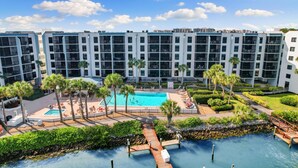 A modern hotel with a rooftop pool, palm trees, and a clear blue sky. - Luxury Waterfront 2BR/2BA Marco Island condo (Marco Island)