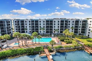 A modern hotel with a rooftop pool, palm trees, and a clear blue sky. - Luxury Waterfront 2BR/2BA Marco Island condo (Marco Island)