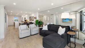 A modern living room with a grey sectional sofa, a white armchair, and a small table with a lamp. - Luxury Waterfront 2BR/2BA Marco Island condo (Marco Island)