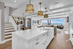A spacious kitchen with a large island, white cabinetry, and pendant lighting. - Luxury Newport Beach House with Rooftop Sunset Deck, Hot Tub and Game Room (Newport Beach)