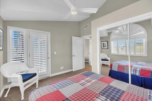 Une chambre à coucher avec un lit, une chaise et une porte.