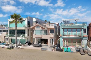 A modern multi-story building with a balcony, outdoor seating, and a pool area. - 4207 Seashore Beachfront Oasis Rooftop and Firepit, Sleep 12 (Newport Beach)