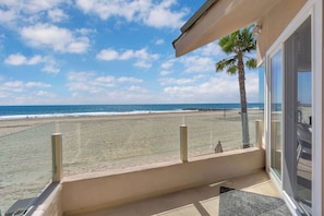 Un balcon avec vue sur une plage et l’océan.