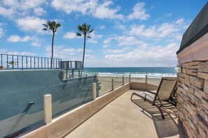 Un balcon doté d’une barrière en verre, une piscine et une vue sur l’océan.