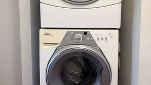 A stacked washer and dryer unit in a room. - Cozy 2BR Near Zoo, Downtown & Max Bell (Calgary)
