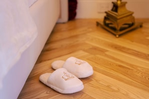 A wooden floor with a pair of slippers and a brass lamp.