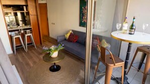 A modern living room with a sofa, a round coffee table, and a dining area with a table and chairs. - Charming Providencia Apartment, 1min from subway, close to costanera center, parking (Providencia)
