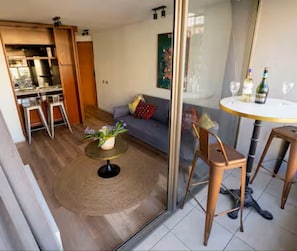 A modern living room with a sofa, a round coffee table, and a dining area with a table and chairs. - Charming Providencia Apartment, 1min from subway, close to costanera center, parking (Providencia)