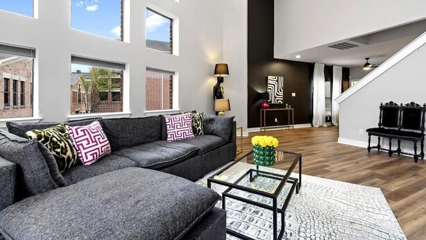 Ein modernes Wohnzimmer mit einem Ecksofa, einem Couchtisch und einer Treppe, die in eine obere Ebene führt.