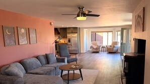 A living room with a sectional sofa, a coffee table, a TV, and a ceiling fan. - Escape to quiet pines under star-filled skies (Pine)