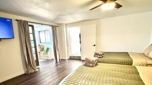 A room with two beds, a ceiling fan, a TV, and a view of the outdoors. - Escape to quiet pines under star-filled skies (Pine)