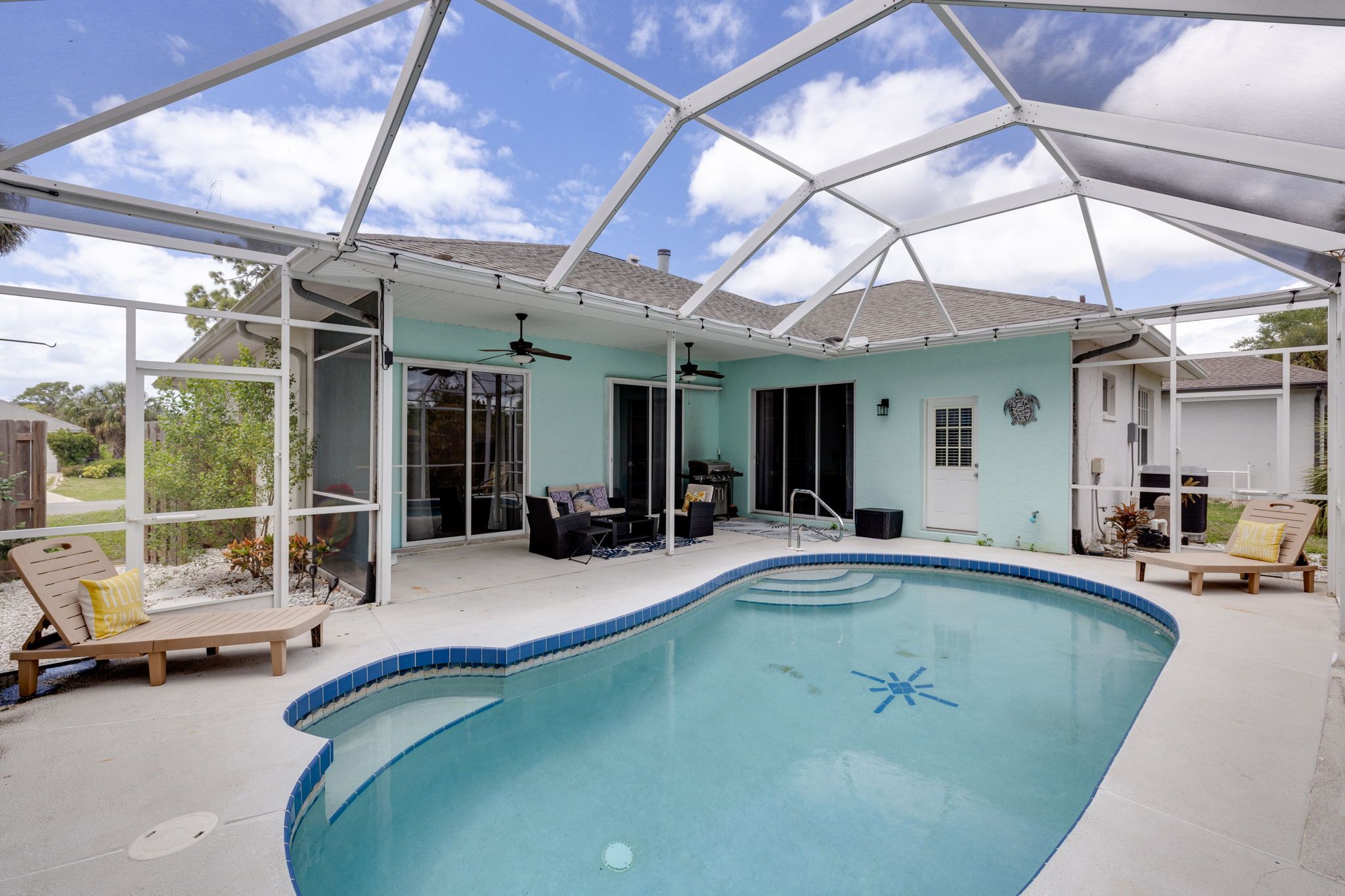 Una piscina techada con estructura de techo, un área de patio con asientos y vistas del paisaje circundante.