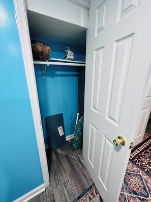 Ein Flur mit blauer Wand, einer weißen Tür und einem gemusterten Teppich.