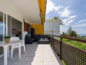 A balcony with a sofa, chairs, a table, and a potted plant. - Rocas Rojas Suites San Agustin I (Maspalomas)
