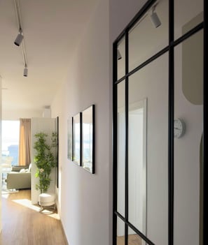 A modern living room with a sofa, a coffee table, and a plant. - Stelvio - Sea Residence (Sarandë)