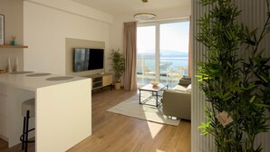 Ein zeitgemäßer Wohnraum mit Küche, Essbereich und großem Fenster mit Blick.