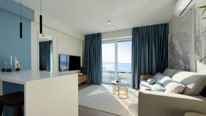 Ein modernes Wohnzimmer mit Flachbildfernseher, einer Couch, einem Essbereich und einem Balkon mit Blick.