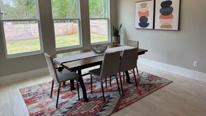 A dining area with a table, chairs, a rug, and artwork on the wall. - House in Conroe (Conroe)