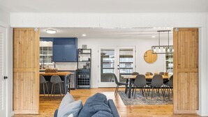 A modern open-plan living space with a kitchen, dining area, and seating area. - Girls Trip Getaway | Pool + Spa Near Main Street (Fredericksburg)