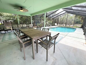 Eine Terrasse im Freien mit Pool, überdachter Sitzgelegenheit und Tisch.