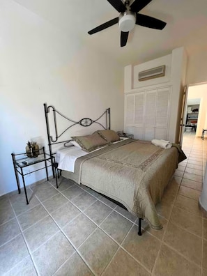 A bedroom with a bed, a bedside table, a ceiling fan, and a wardrobe. - Casa Mariposas Ixtapa Pet Friendly Eco-Villa with Unlimited A/C and Solar Energy (Ixtapa Zihuatanejo)