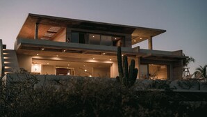 A modern two-story house with a flat roof, large windows, and a well-lit interior. - Luxury Ocean View, Modern Mexican Design + Epic Views
5 bedrooms, Sleeps 16 (playa tortuga)
