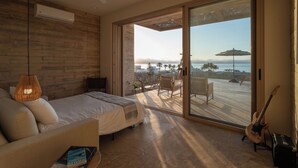 A bedroom with a bed, a ceiling fan, a large sliding glass door leading to a balcony with outdoor furniture and a guitar. - Luxury Ocean View, Modern Mexican Design + Epic Views
5 bedrooms, Sleeps 16 (playa tortuga)