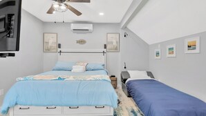 A bedroom with a bed, a ceiling fan, an air conditioner, and artwork on the walls. - 1 Bedroom Studio in Waterfront Building with Dock Access (Treasure Island)