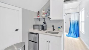 A compact kitchen with a microwave, sink, and stainless steel refrigerator. - 1 Bedroom Studio in Waterfront Building with Dock Access (Treasure Island)