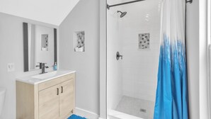A modern bathroom with a shower, a sink, and a mirror. - 1 Bedroom Studio in Waterfront Building with Dock Access (Treasure Island)
