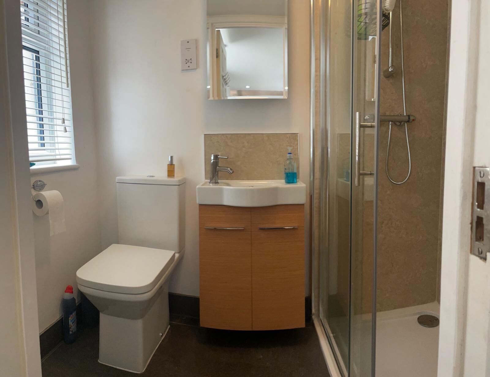 Un bagno con WC, lavandino, specchio e doccia.