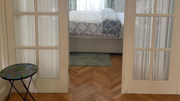 A room with a bed, a small table, and a herringbone-patterned floor. - Gorgeous One Bedroom Flat in Woolwich Arsenal (London)